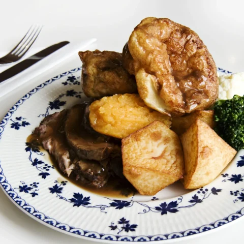 Roast beef dinner with yorkshire pudding, roast potatoes and vegetables