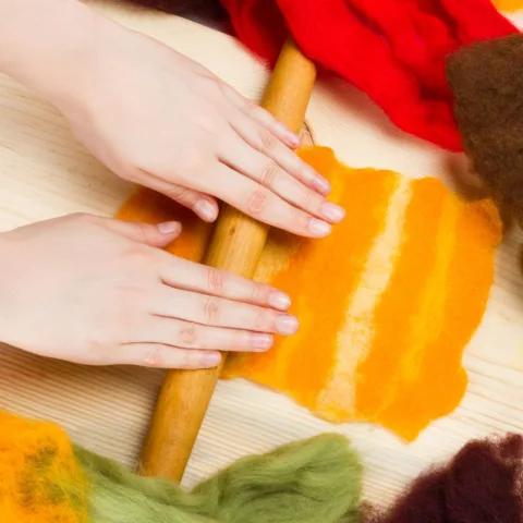 Detail of hands playing with felt
