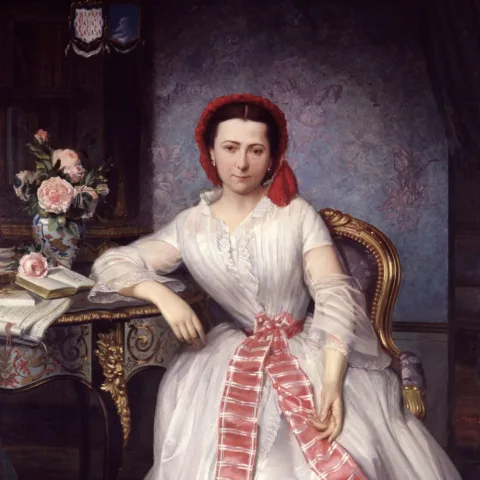 A 19th-century portrait of a seated woman in an elegant white dress adorned with a pink ribbon, wearing a red headscarf. She rests one arm on a decorative table holding a vase of roses and an open book. The background features ornate furniture and wallpaper.