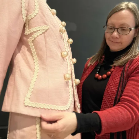 Image of the fashion curator adding the final details to the costumes