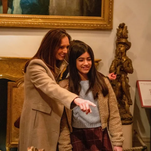 Image of a woman and child looking around the Museum galleries and pointing at an object whilst smiling.