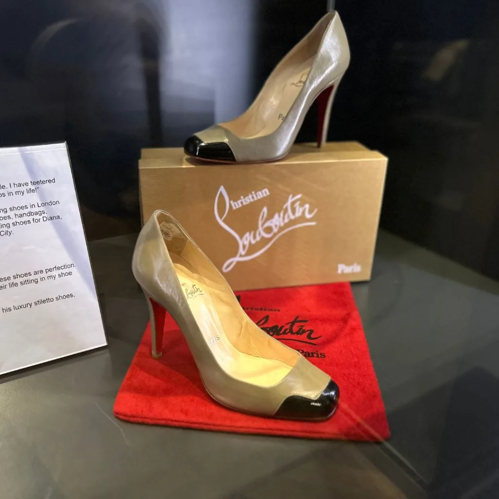 Image of a pair of cream high heel Louboutin shoes with red sole