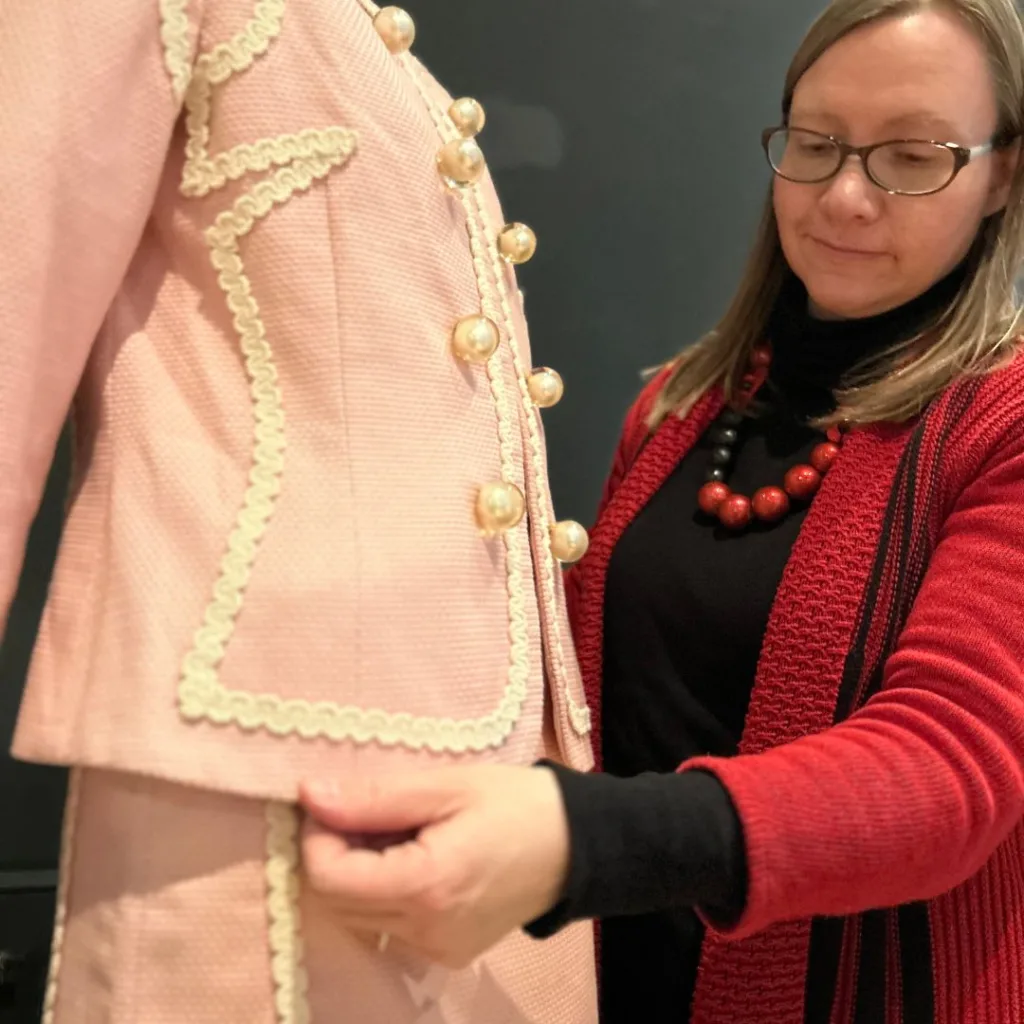 Image of the fashion curator adding the final details to the costumes