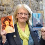 Author Val Scully holding up two of her books