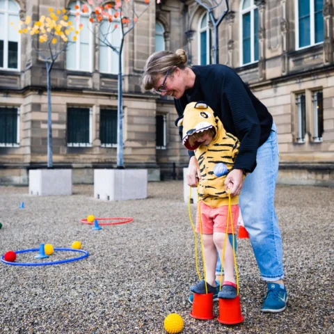Image of an adult and child playing with outdoor toys in the Museum grounds