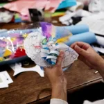 Hands working on a mixed-media craft activity.