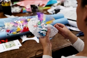 Hands working on a mixed-media craft activity.