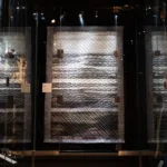 Image of a black and white quilt hanging in a display case in the Fashion and Textile Gallery of The Bowes Museum.