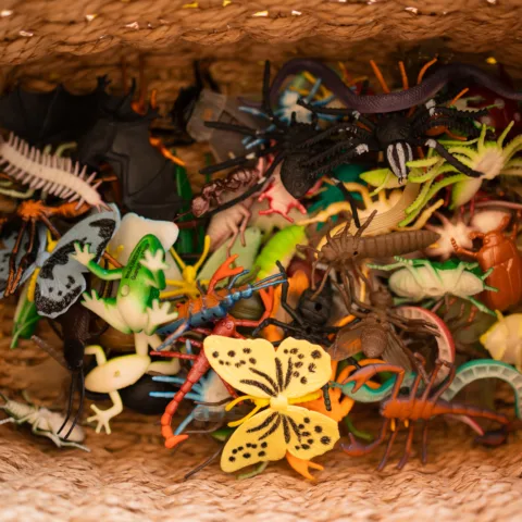 A basket full of toy bugs and small animals.