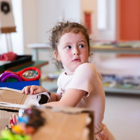 A young girl with her hand in a box