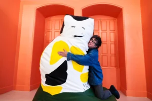 Pippa Hale hugging a giant cat black, white and yellow squishee