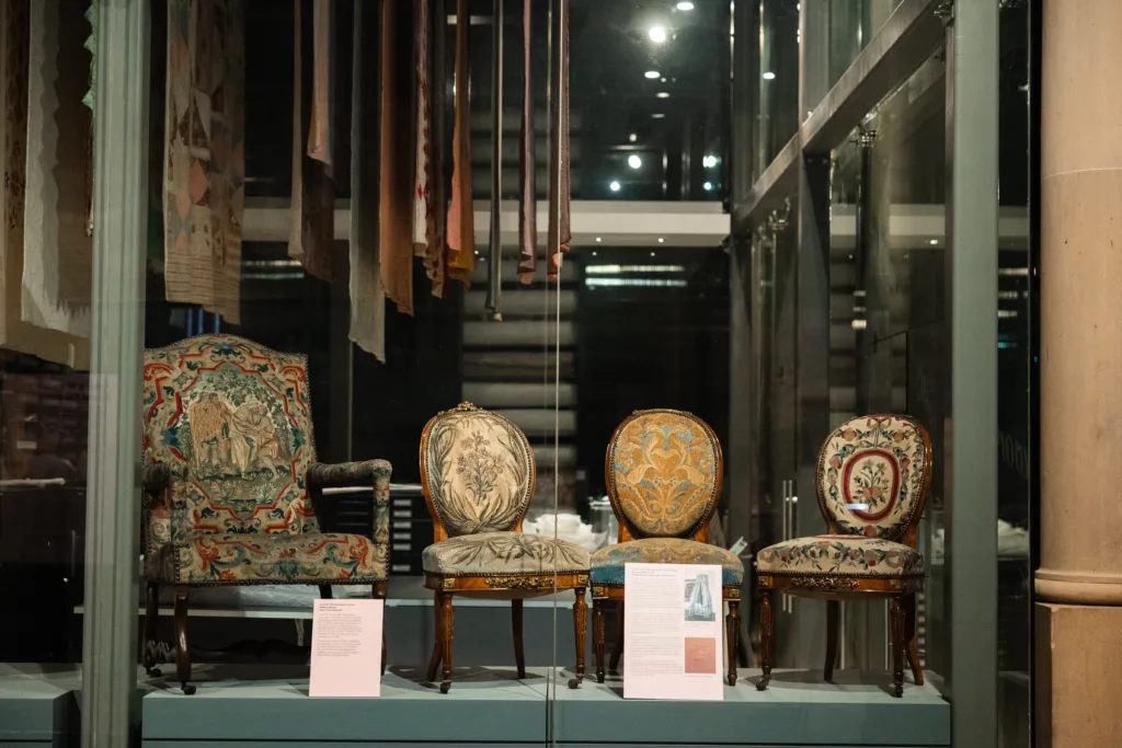 A Woman of Taste and Fashion exhibition display including embroidered chairs
