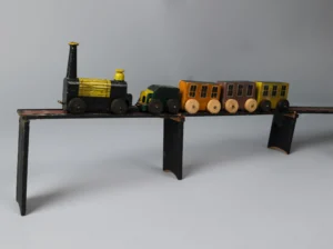 A vintage wooden toy train set featuring a black and yellow locomotive with several colourful passenger cars displayed on a raised track.