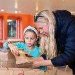 A girl and her mum doings crafts in the create space.