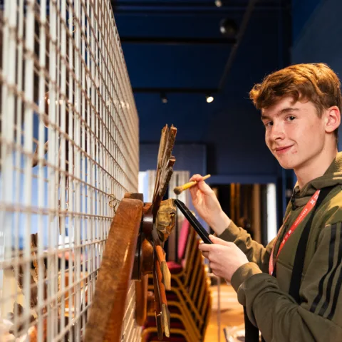 A young volunteer cleaning an object.