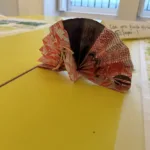 Paper fan with a pink pattern.