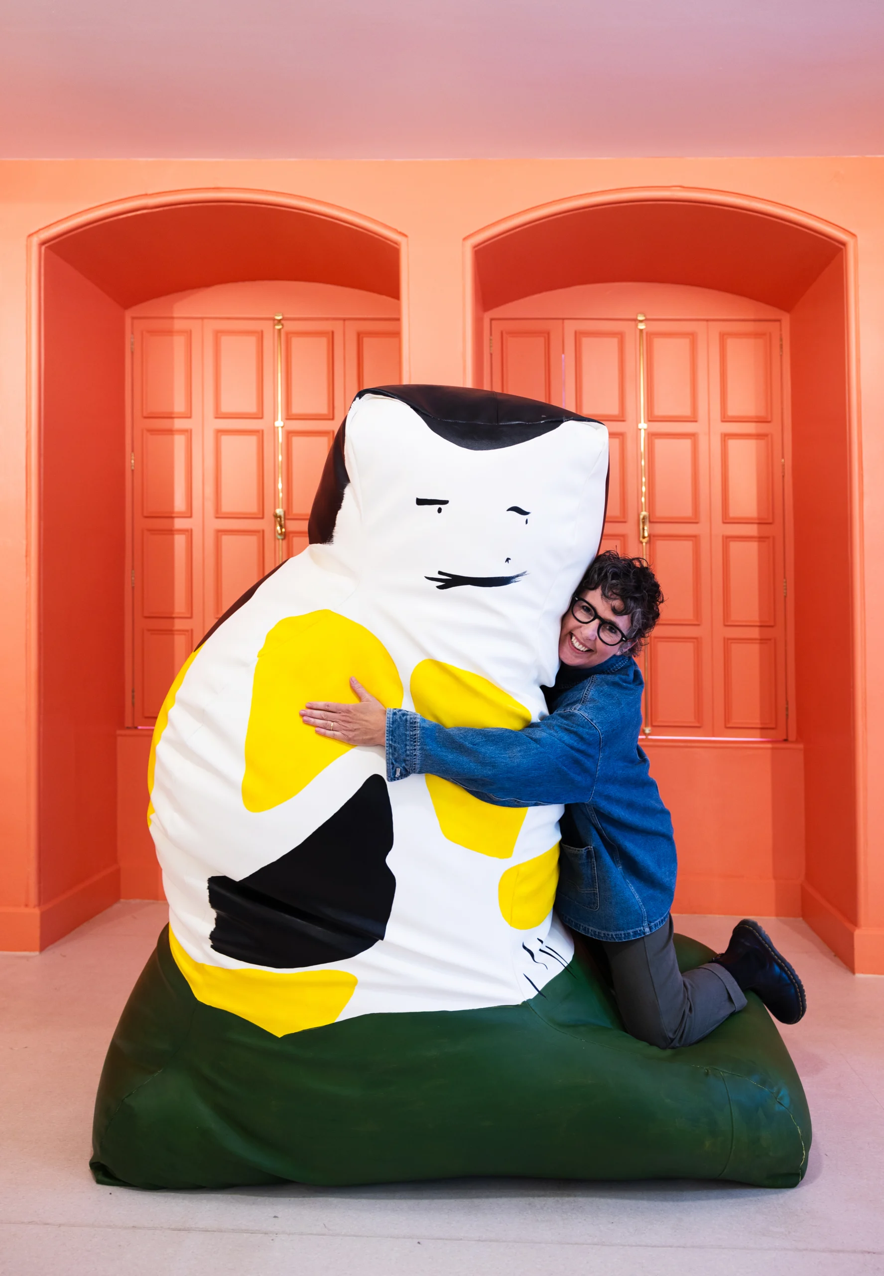 Pippa Hale hugging a giant cat black, white and yellow squishee