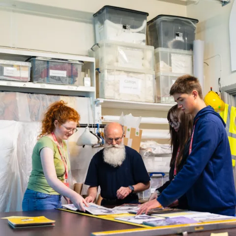 A member of museum staff teaching young people about the collection