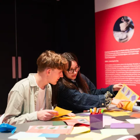 Two young people creating animal origami in Pippa Hale: Pet Project
