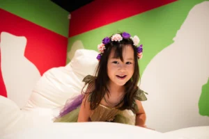 A young girl wearing a fairy costume playing the in Pippa Hale Pet Project exhibition