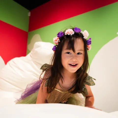 A young girl wearing a fairy costume playing the in Pippa Hale Pet Project exhibition
