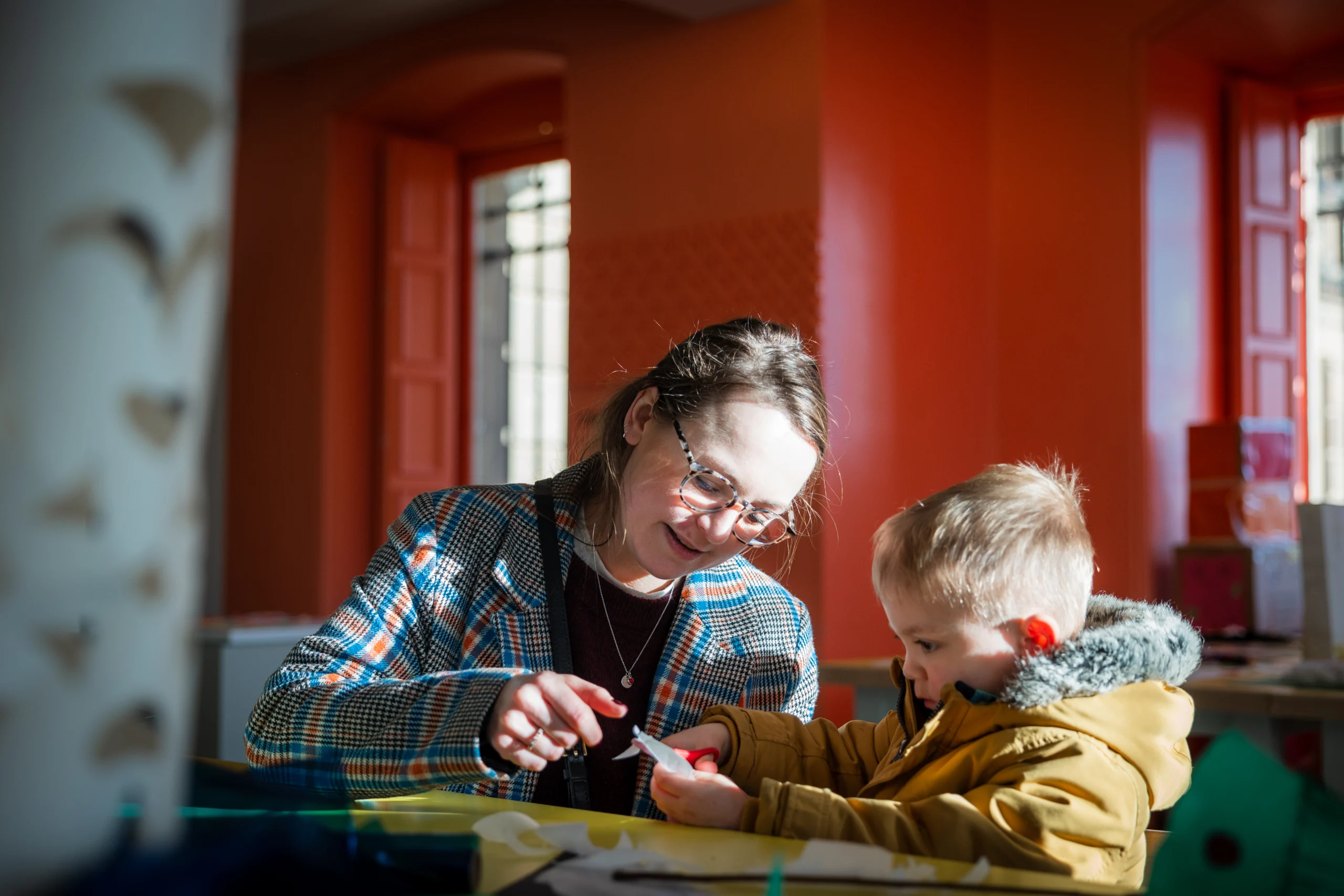 A woman and her child creating art in a gallery space
