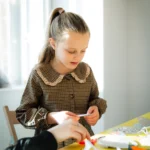 A young girl making art in a bright gallery space